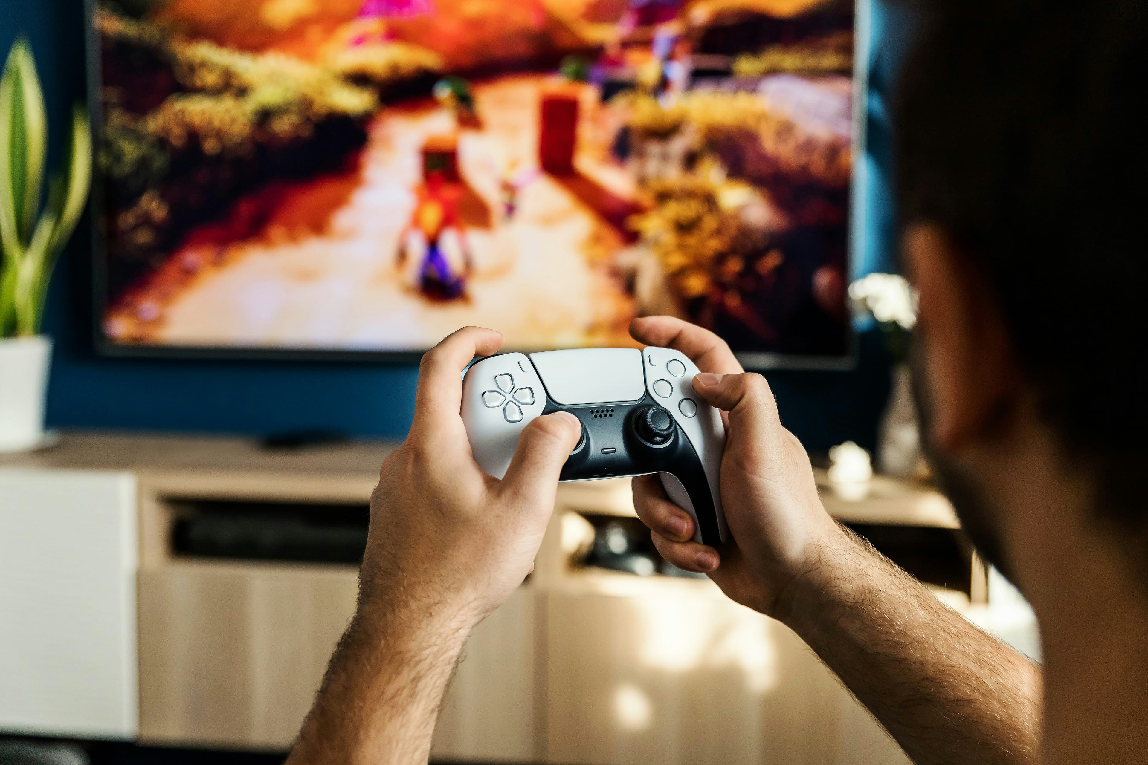 Мужчина играет в видеоигру с контроллером перед экраном